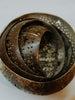 Inside view of carved coconut lamp shade showing warm light pattern from patio string bulb