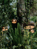 Coconut shell string light shade with carved pattern glowing in garden setting