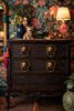 Dark academia dresser styling with ornate brass cat head drawer pulls as statement cabinet hardware