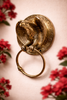 Decorative brass eagle towel ring styled with flowers, luxury wall decor accent