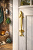 Brass dolphin door handle installed on front door for coastal entryway decor