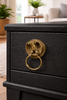 Close up of brass eagle drawer pull installed on furniture vintage cabinet hardware detail