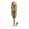 Single gold brass feather wall hook on a white background, showing detailed carved feather veins, two screw holes and a curved hook with rounded ball tip. Handmade cast brass coat, towel and key hook from Ubud, Bali, part of the brass feather wall hook set of 2.