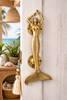 Gold mermaid door handle installed on entry door for coastal and nautical home decor.