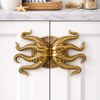 gold finish cotopus cabinet oor pull on white double door cabinet in a nautical decor room