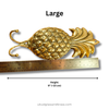 Gold pineapple decorative hook  with a ruler for scale on a white background