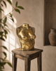 Brass female torso sculpture displayed on side table in luxury interior, gold body sculpture for maximalist decor, eclectic home decor, bold statement decor