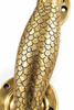 Close-up of decorative brass mermaid scales on entry door handle
