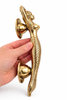 Side profile of brass mermaid door handle showing mounting depth and shape