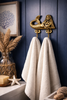 Brass mermaid double wall hook holding towels in coastal bathroom decor setting