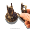 Mini brass mudra hand hooks shown in hand for size scale, left and right pair