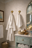 Brass seashell wall hook set used in nautical bathroom decor with hanging towels