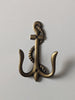 Front view of brass anchor wall hook for nautical decor coastal interiors and beach house bathroom
