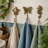 Brass turtle, butterfly, and seahorse wall hooks holding towels, handmade nautical coastal coat hook set.