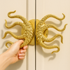 Pair of brass octopus handles installed on double entry doors as statement hardware
