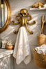 Brass octopus towel hook in coastal bathroom interior, nautical wall decor robe hanger