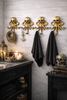 Brass octopus wall hooks installed in bathroom holding towels luxury nautical decor