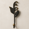 Single patina brass sprout leaf hook in a dark aged bronze finish on a cream background