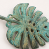 Close up texture of patina monstera leaf wall hook showing aged green finish and handmade detail