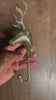 Video of the rustic brass reindeer wall hook held in a hand against a wooden door, turned to show the stag's head, branching antlers and curved hook. Handmade brass deer hook from Ubud, Bali.