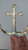 Video showing a hand holding a brass anchor wall hook against a blue background, nautical coat hook installation