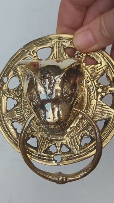 Video of the brass cat head towel ring held in a hand and turned to show the sculpted cat face, ornate scrollwork plate and solid brass ring. Handmade gothic door knocker and drawer pull from Ubud, Bali.