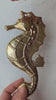 Video of solid brass seahorse wall hook held in hand showing detailed scale texture fin detail and full sculptural body for scale — nautical seahorse hook set of 4 coastal decor handmade in Bali