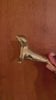 Video of the brass seal bottle opener held in a hand and turned to show the seal's polished gold brass body, flippers and bottle-opening loop. Handmade animal bottle opener from Ubud, Bali.