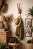 Brass impala animal wall hook used in safari style entryway decor holding hat and coat