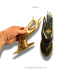 Hand holding single brass Buddha mudra hand showing size and oval base, decorative door pull and wall hook