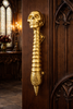 Skull spine door handle installed on an entry door for gothic dark academia hardware style