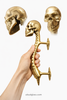 Hand holding skull spine door handle showing size and mounting posts for installation
