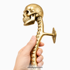 Side profile of skull spine door handle in hand showing depth from door and overall scale