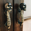 Skull spine door handles installed as a matching pair on double doors for gothic entry hardware