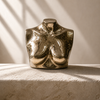 Small solid brass female torso sculpture on a stone ledge in dramatic side light — gold body art for maximalist eclectic decor, housewarming gift for him and her handcrafted in Bali