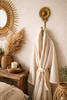 Brass sunflower hook used as a robe and towel hook in a cottagecore bathroom.