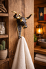 Texas longhorn brass wall hook used as towel hanger in rustic bathroom, western towel hook and wall decor.