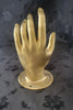 galss solid brass hand shake door pull on a dark background