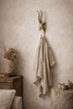 Brass impala animal wall hook in wabi sabi interior decor holding linen cloth