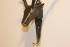 close up of antique bronze deer head brass towel holder on the wall 