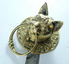 Front centered studio shot of brass cat head ring pull, decorative cabinet hardware.