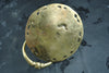 Back of the brass cat head towel ring on dark fabric, showing the hand-cast round mounting plate and the ring, an honest view of the handmade cast brass. A vintage towel ring and hand towel holder made by artisans in Ubud, Bali.