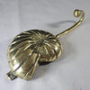 Side view of brass conch shell wall hook showing curved hanger design
