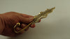 Brass leaf wall hook shown in hand for size reference