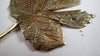 Close up of brass maple leaf hook in an antique patina finish showing hand carved leaf vein texture