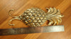 Brass pineapple wall hook flat lay on wooden surface