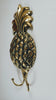 Brass pineapple wall hook shown in hand for size reference