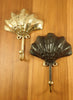 Brass shell wall hook mounted on wooden surface