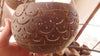 Dark fish scale carved coconut planter held in hand for scale