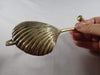 Antique gold brass clam shell wall hook detail for coastal and nautical decor